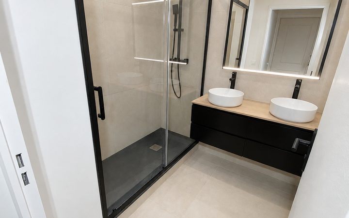 Salle de bains rénovée avec douche vitrée et meuble double vasque